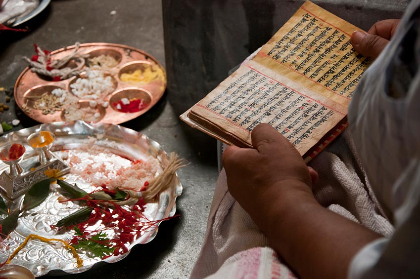 Ayurvedische Speisen befinden sich neben einem alten Buch mit ayurvedischer Lehre in Sanskrit geschrieben.